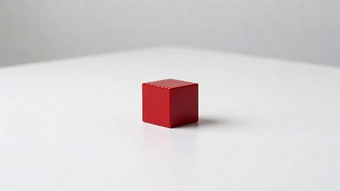 a small red cube on a white table, studio photo